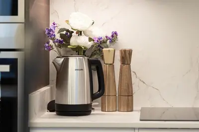 a coffee pot with flowers on a kitchen counter at The Signature Burj Khalifa View Residence with Terrace in Dubai