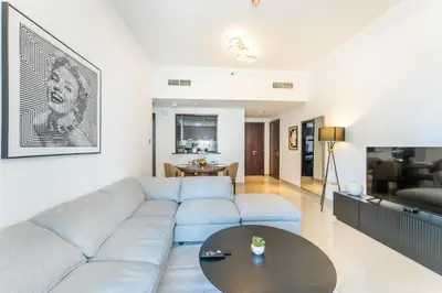 a living room with a couch and a table at Stylish 1 BR in The Medalist by PK Holidays in Dubai