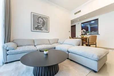 a living room with a couch and a table at Stylish 1 BR in The Medalist by PK Holidays in Dubai