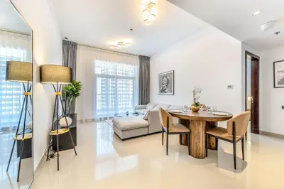 a living room with a table and a couch at Stylish 1 BR in The Medalist by PK Holidays in Dubai