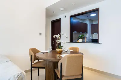 a dining room with a wooden table and chairs at Stylish 1 BR in The Medalist by PK Holidays in Dubai