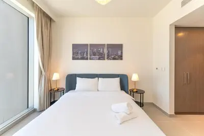 a bedroom with a large white bed with two lamps at Charming Apartment in Downtown Just Steps from Burj Khalifa & Dubai Mall by Bhavan Vacation Homes in Dubai