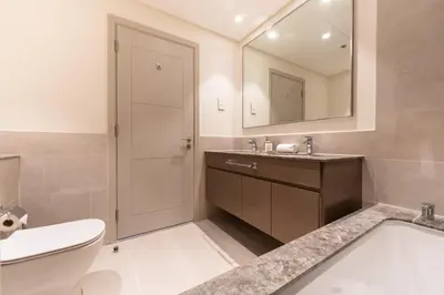 a bathroom with a sink and a toilet and a mirror at Charming Apartment in Downtown Just Steps from Burj Khalifa & Dubai Mall by Bhavan Vacation Homes in Dubai