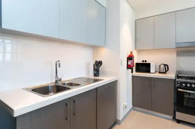 a kitchen with white cabinets and a sink at Charming Apartment in Downtown Just Steps from Burj Khalifa & Dubai Mall by Bhavan Vacation Homes in Dubai