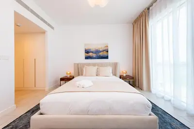 a white bedroom with a large bed and windows at Remarkable 2BR+storage in JBR with Sea View in Dubai