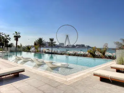a large swimming pool with a ferris wheel in the background at Remarkable 2BR+storage in JBR with Sea View in Dubai