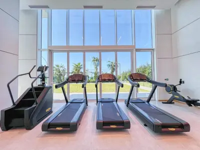 a row of treadmills in a gym with a large window at Remarkable 2BR+storage in JBR with Sea View in Dubai