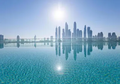 a city skyline with the sun reflecting in the water at Marina Skyline View & Dubai Harbour Beachfront in Dubai