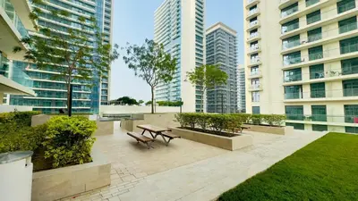 a park with a bench and a table and some buildings at Marina Skyline View & Dubai Harbour Beachfront in Dubai