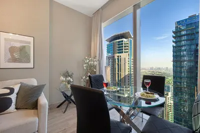 a living room with a glass table and a view of a city at Livin' Holidays - Luxury apartment in Dubai Marina in Dubai