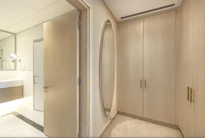a bathroom with wooden cabinets and a mirror at Elegant 1BR in Palm Tower, Nakheel Mall, Sea View in Dubai