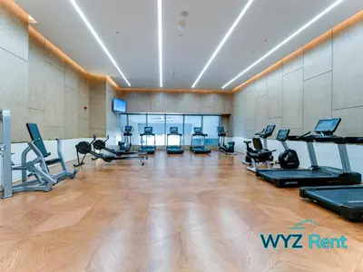 a gym with treadmills elliptical machines and treadleys at Elegant 1BR in Palm Tower, Nakheel Mall, Sea View in Dubai