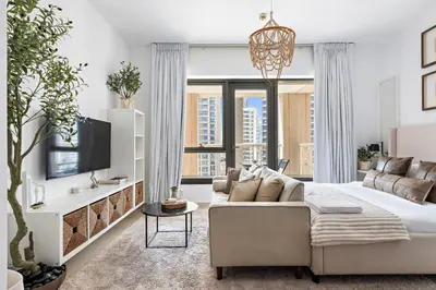 a living room with a couch and a tv at Silkhaus Modern Studio Near Burj Khalifa in Dubai