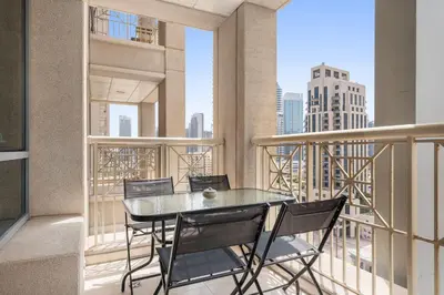 a table and chairs on a balcony with a view at Silkhaus Modern Studio Near Burj Khalifa in Dubai