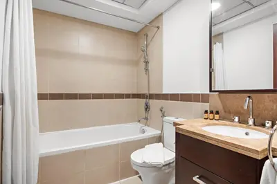 a bathroom with a tub and a toilet and a sink at Silkhaus Modern Studio Near Burj Khalifa in Dubai