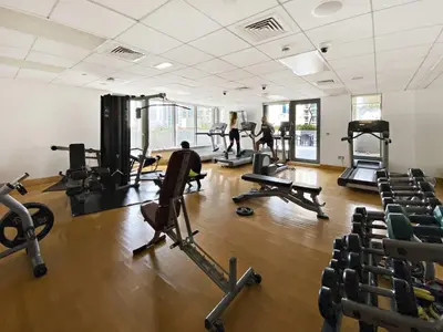 a gym with tread machines and people in the background at Silkhaus Modern Studio Near Burj Khalifa in Dubai