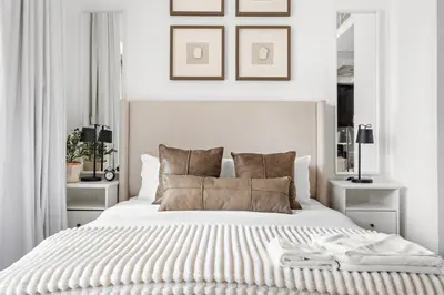 a white bedroom with a large white bed with pillows at Silkhaus Modern Studio Near Burj Khalifa in Dubai