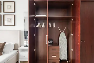 a bedroom with a closet with a wooden door at Silkhaus Modern Studio Near Burj Khalifa in Dubai