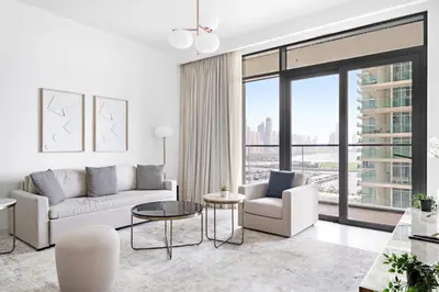 a living room with white furniture and a large window at Silkhaus Sea and City View 1BDR in Marina Vista in Dubai