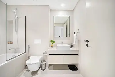 a white bathroom with a sink and a toilet at Silkhaus Sea and City View 1BDR in Marina Vista in Dubai
