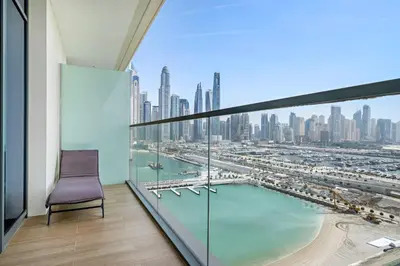 a chair on a balcony with a view of a city at Silkhaus Sea and City View 1BDR in Marina Vista in Dubai