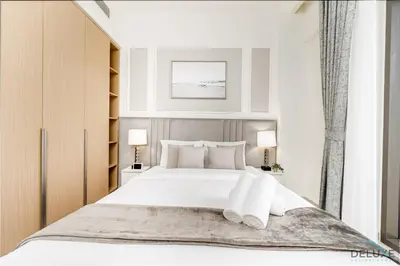 a bedroom with a large white bed and two lamps at Lavish 1BR Apartment at Summer at Creek Beach, Dubai Creek Harbor by Deluxe Holiday Homes in Dubai