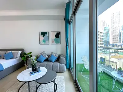 a living room with a couch and a table at Lxury Brand New Studio w/ Balcony and Marina View in Dubai
