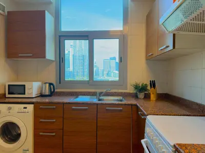a kitchen with a sink and a window at Lxury Brand New Studio w/ Balcony and Marina View in Dubai