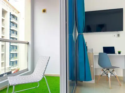 a living room with two chairs and a television at Lxury Brand New Studio w/ Balcony and Marina View in Dubai