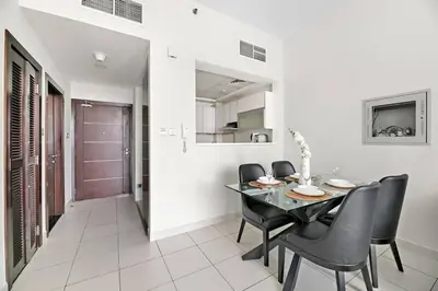 a dining room with a table and black chairs at StoneTree - Furnished 1 BR - Glitz 3 in Dubai