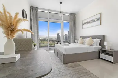 a white bedroom with a large bed and a couch at StoneTree - Modern Studio - Carson A in Dubai