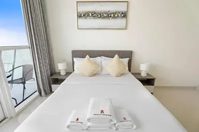 a bedroom with a bed with two towels on it at StoneTree - Modern Studio - Carson A in Dubai