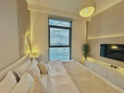 a bedroom with a bed and a large window at Your Private Beach Sunny Retreat in Dubai