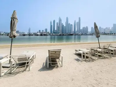 a group of chairs and umbrellas on a beach at Your Private Beach Sunny Retreat in Dubai