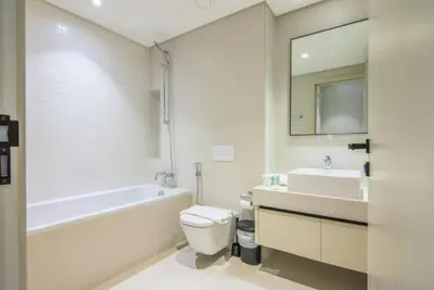 a bathroom with a tub and a toilet and a sink at Your Private Beach Sunny Retreat in Dubai