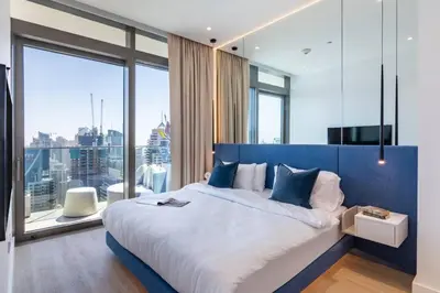 a bedroom with a large bed with a large window at FIRST CLASS 1BR High Floor with Magical View in Dubai