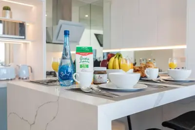 a kitchen counter with a table with bowls and bottles at FIRST CLASS 1BR High Floor with Magical View in Dubai
