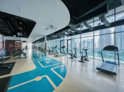 a gym with treadmills and exercise equipment in a building at FIRST CLASS 1BR High Floor with Magical View in Dubai