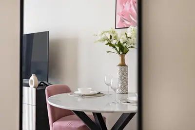 a dining room table with a vase of flowers on it at Cozy Studio in Al Furjan in Dubai