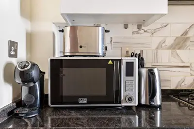 a microwave sitting on top of a counter in a kitchen at Cozy Studio in Al Furjan in Dubai