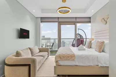 a bedroom with a bed and a couch and a window at High Floor Burj Khalifa & Sea View with stunning Infinity Pool in Dubai