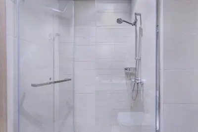 a shower with a glass door in a bathroom at Tranquil Studio Retreat in Azizi 34 Near Downtown in Dubai