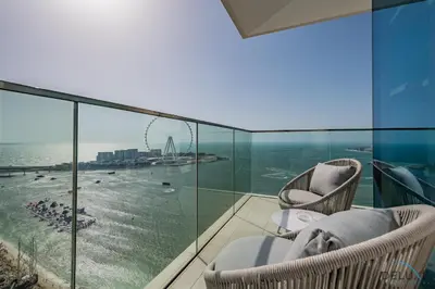 a balcony with chairs and a view of the ocean at Elegant 2BR Apartment in La Vie, JBR by Deluxe Holiday Homes in Dubai