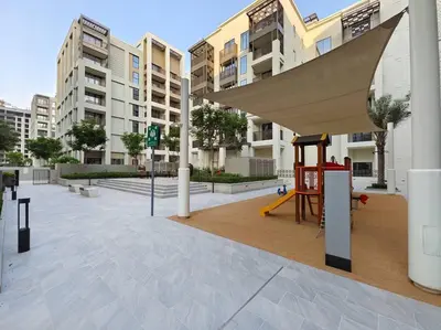 a playground in front of a building with a swing at Creek Beachfront Heaven: 1BR Luxe Harbor Flat in Dubai