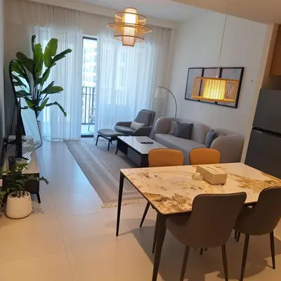 a living room with a couch and a table at Creek Beachfront Heaven: 1BR Luxe Harbor Flat in Dubai