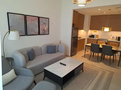a living room with a couch and a table at Creek Beachfront Heaven: 1BR Luxe Harbor Flat in Dubai