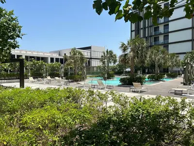 a resort with a pool and chairs and a building at Bluewaters Island - Modern 2 bedroom Full Apartment in Dubai