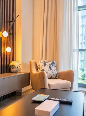a living room with a chair and a table at Modern Downtown Escape 1Bedroom with Upscale Comfort in Dubai