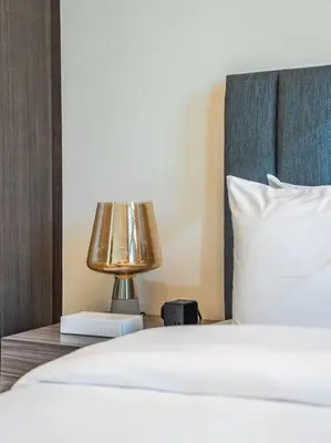 a bed with a nightstand with a lamp on it at Modern Downtown Escape 1Bedroom with Upscale Comfort in Dubai