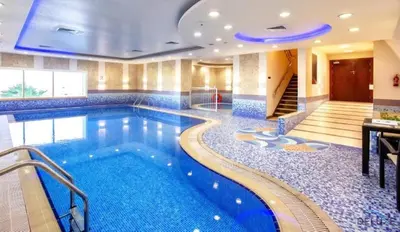 a swimming pool in a hotel with blue tiles at Modern 1BR Apartment in Elite Residences, Dubai Marina by Deluxe Holiday Homes in Dubai